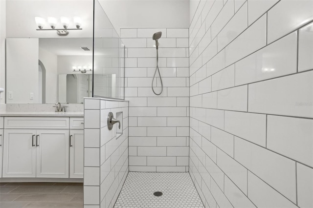 bathroom with vanity and a tile shower