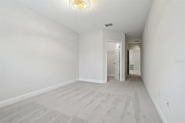 carpeted spare room featuring a textured ceiling