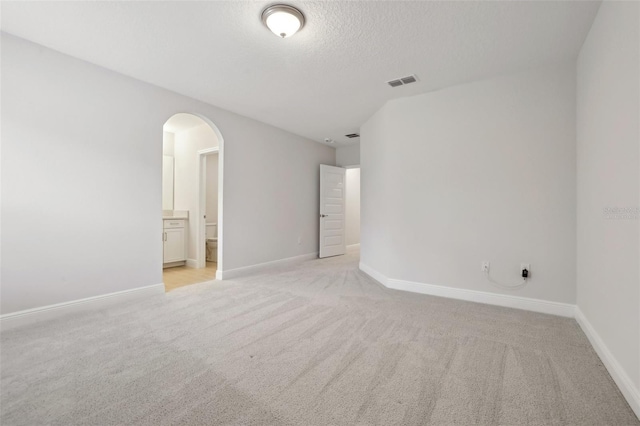 unfurnished room with light colored carpet and a textured ceiling