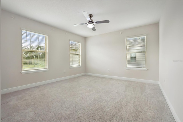 spare room with ceiling fan and light colored carpet