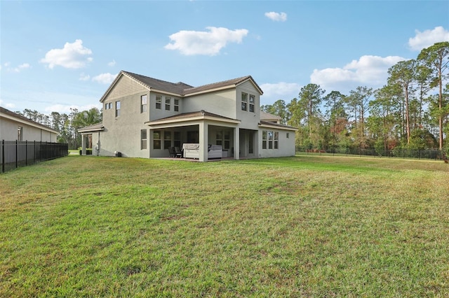 back of house featuring a lawn and a patio area