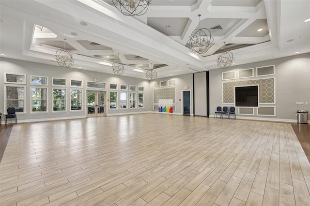 exercise room with a chandelier and coffered ceiling