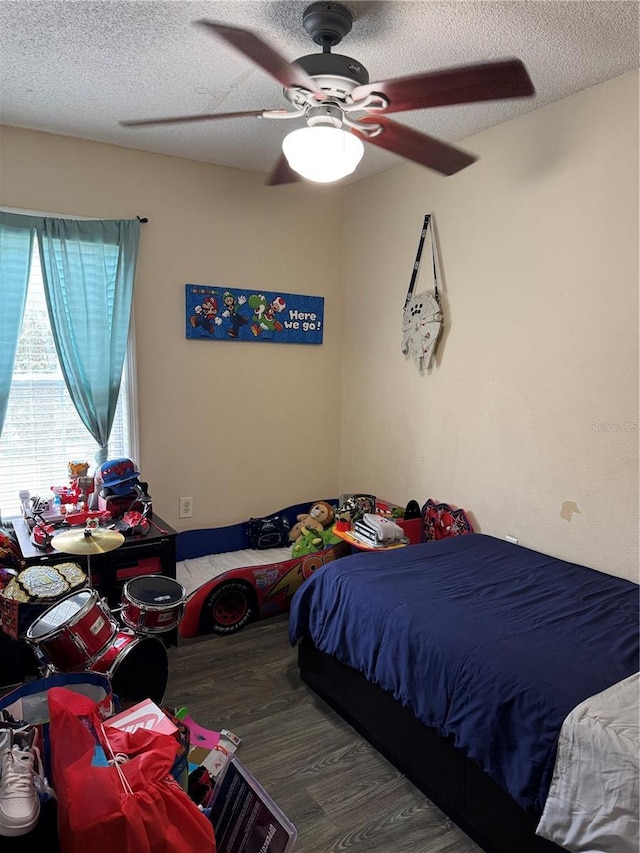 bedroom with ceiling fan, a textured ceiling, and wood-type flooring