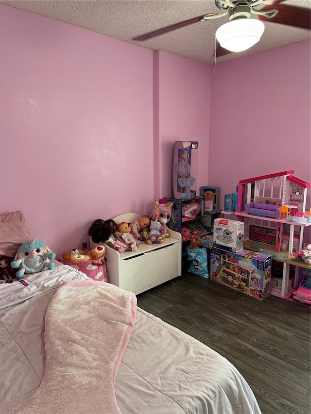 bedroom with ceiling fan, a textured ceiling, and dark hardwood / wood-style floors