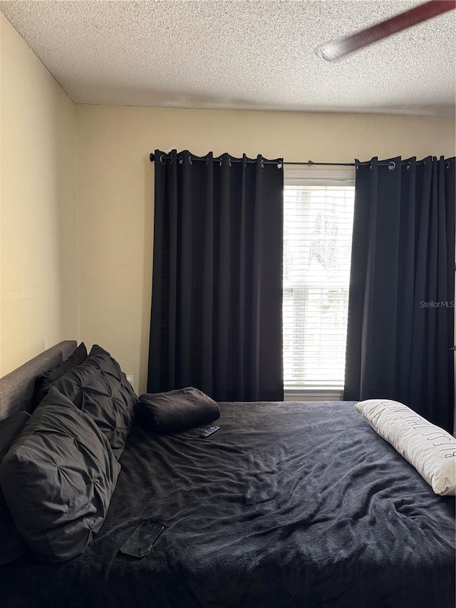 bedroom with a textured ceiling and ceiling fan