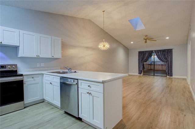 kitchen featuring appliances with stainless steel finishes, white cabinetry, decorative light fixtures, and sink