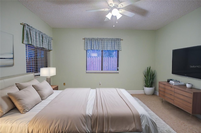 bedroom featuring ceiling fan, a textured ceiling, and carpet floors