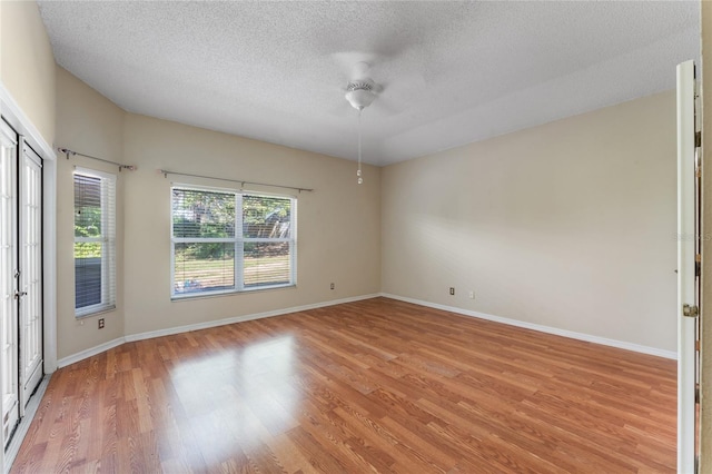 unfurnished room featuring light wood-type flooring and a textured ceiling