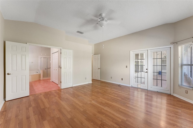 unfurnished bedroom featuring access to outside, french doors, connected bathroom, light wood-type flooring, and ceiling fan