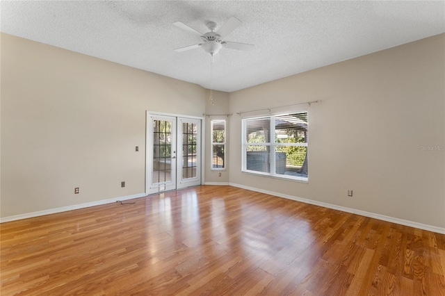 spare room featuring french doors, a textured ceiling, ceiling fan, and light wood-type flooring