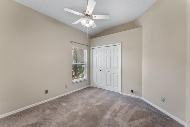 unfurnished bedroom with light carpet, a closet, ceiling fan, and vaulted ceiling