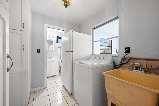 laundry area with washer / dryer, light tile patterned floors, and sink