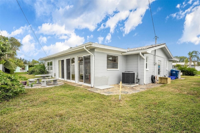 rear view of property with a lawn and central AC