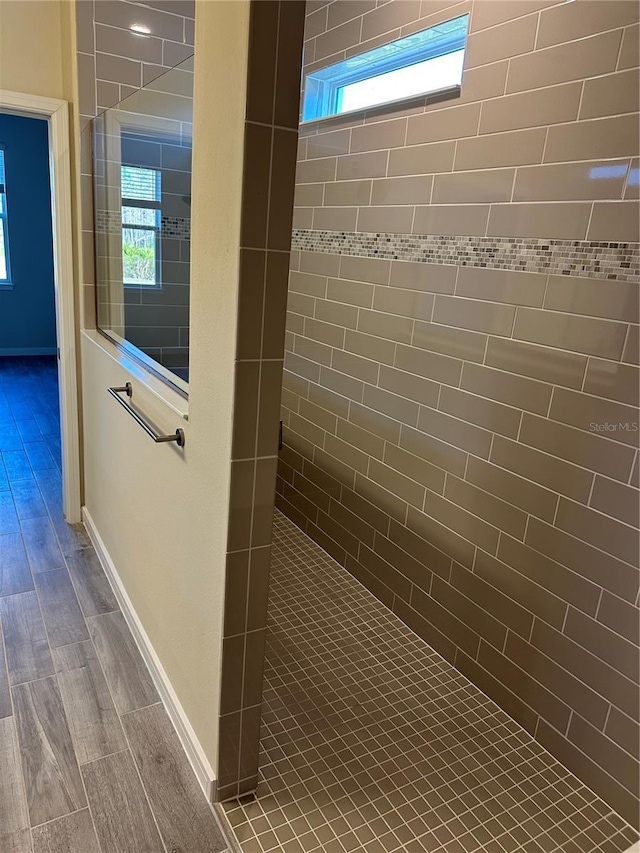 hallway with wood-type flooring and a healthy amount of sunlight