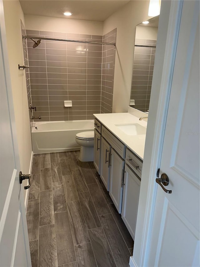 full bathroom with toilet, vanity, and tiled shower / bath combo