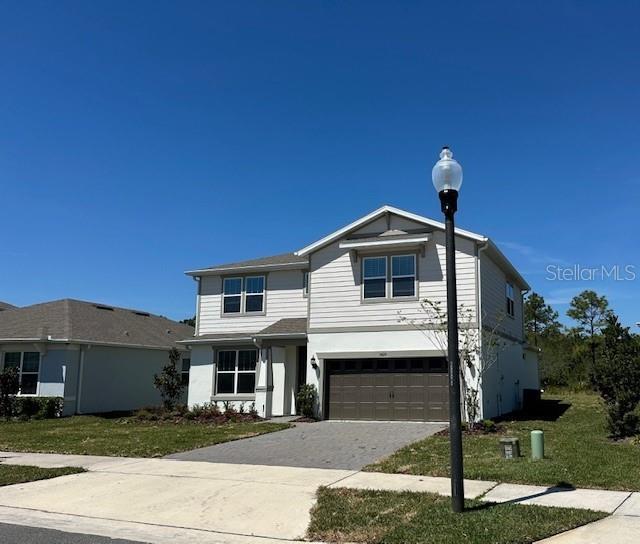 5425 Log Grove Ln, Orlando, FL 32829 - traditional-style house featuring driveway, an attached garage, and a front lawn