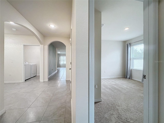 corridor featuring washer and clothes dryer and light carpet