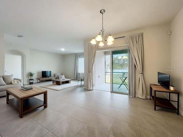 tiled living room with a notable chandelier