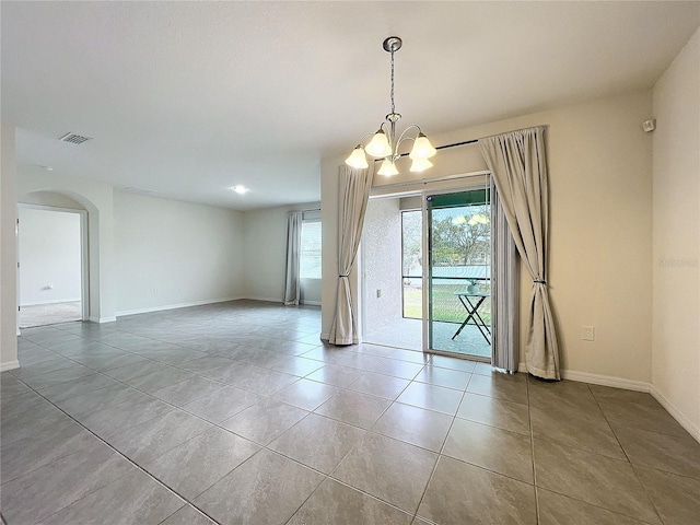 unfurnished room with tile patterned flooring and a chandelier