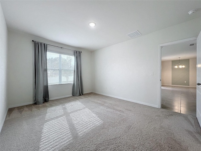 unfurnished room with an inviting chandelier and light colored carpet