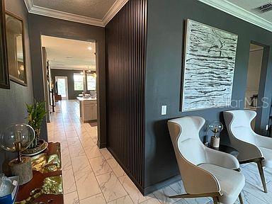 corridor with a textured ceiling and ornamental molding