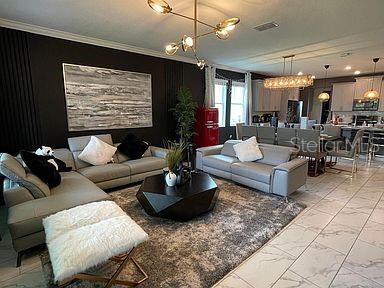 living room featuring an inviting chandelier and ornamental molding