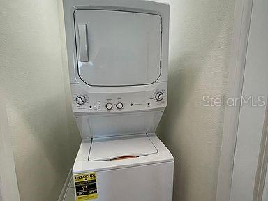 laundry room with stacked washer / dryer