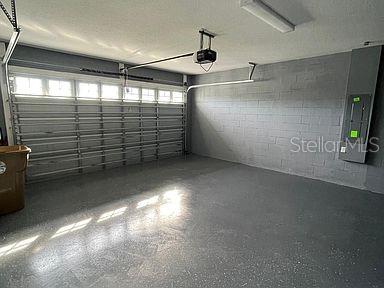 garage with a garage door opener and electric panel