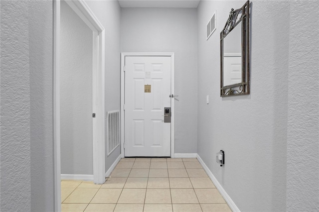 doorway to outside with light tile patterned floors