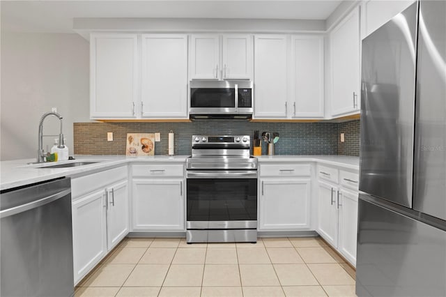 kitchen featuring light tile patterned floors, stainless steel appliances, white cabinets, and sink