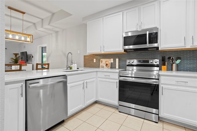 kitchen featuring white cabinetry, appliances with stainless steel finishes, tasteful backsplash, light tile patterned flooring, and hanging light fixtures