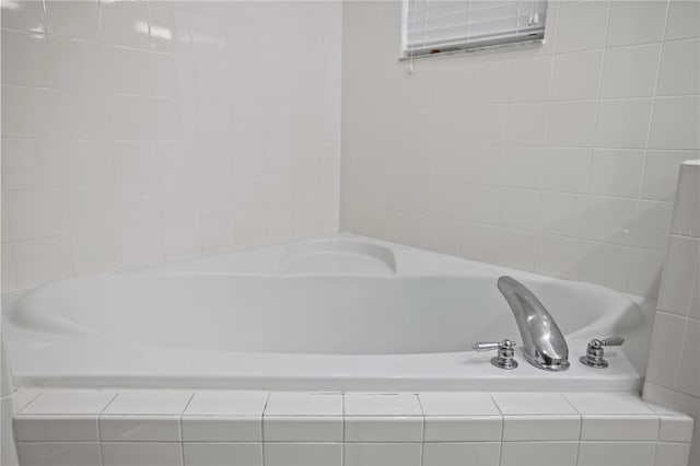 bathroom with a relaxing tiled tub