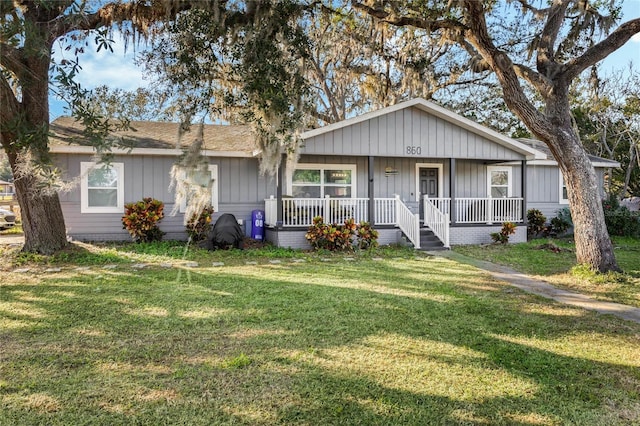 single story home with covered porch and a front lawn