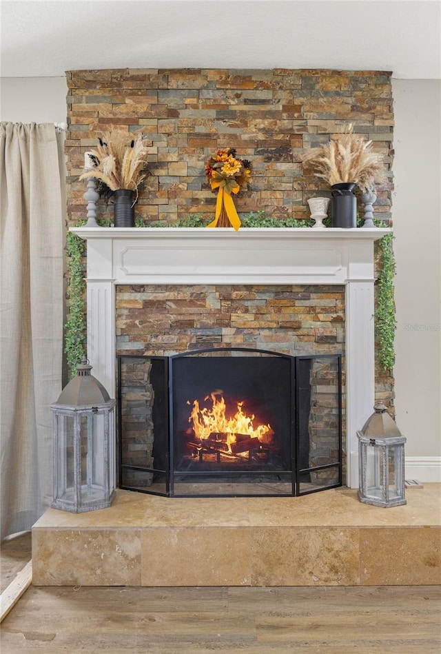 interior details with hardwood / wood-style flooring and a stone fireplace