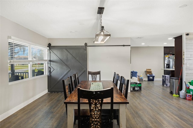 dining room with dark hardwood / wood-style flooring and a barn door