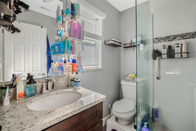 bathroom with walk in shower, vanity, and toilet