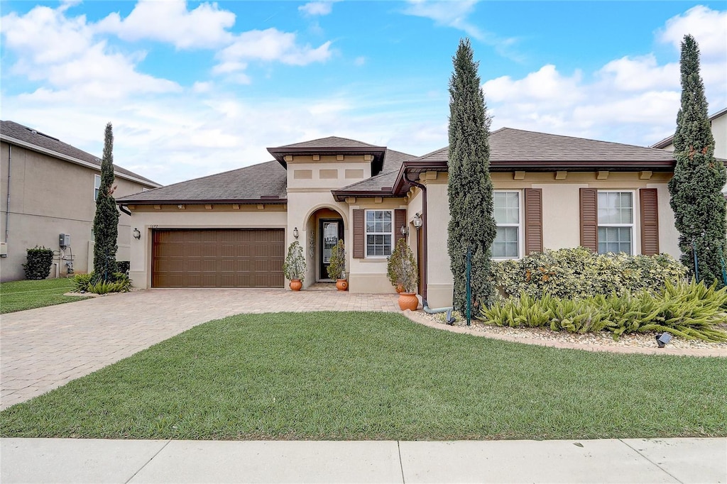 view of front of property featuring a garage and a front lawn