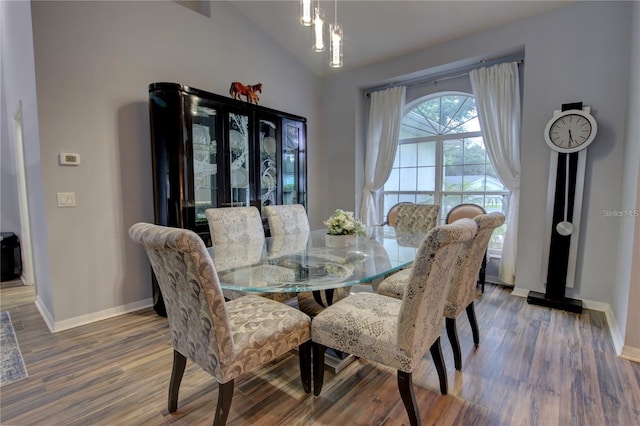 dining room featuring vaulted ceiling and hardwood / wood-style flooring