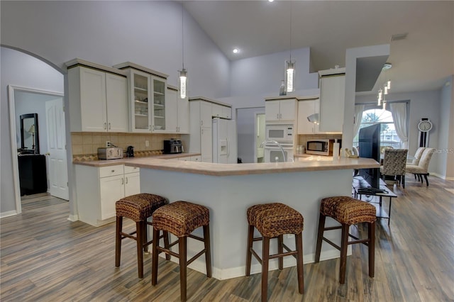 kitchen with white appliances, white cabinets, and kitchen peninsula