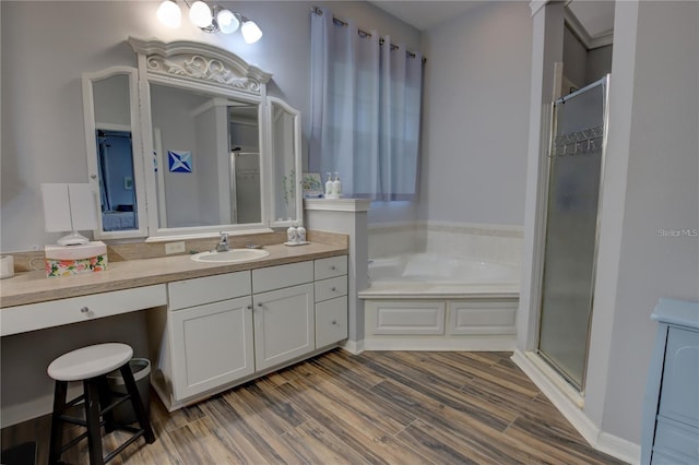 bathroom with hardwood / wood-style flooring, independent shower and bath, and vanity