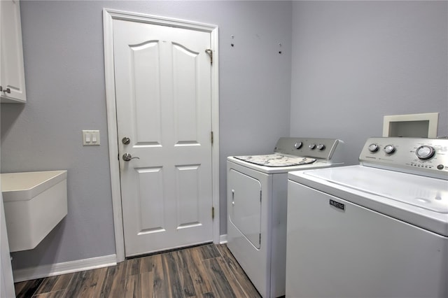 washroom with dark wood-type flooring, cabinets, and separate washer and dryer