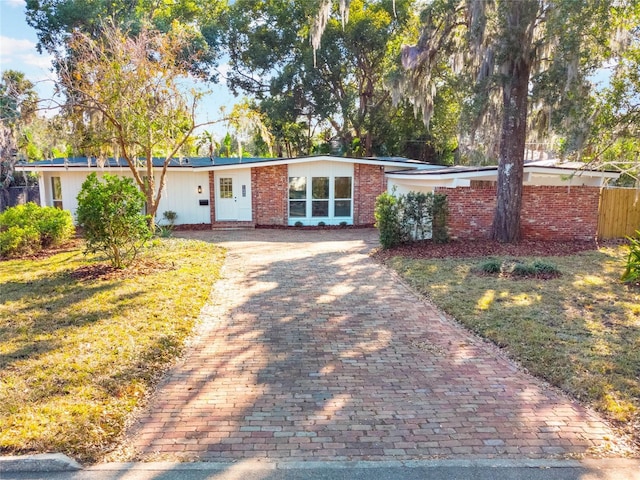 single story home featuring a front lawn