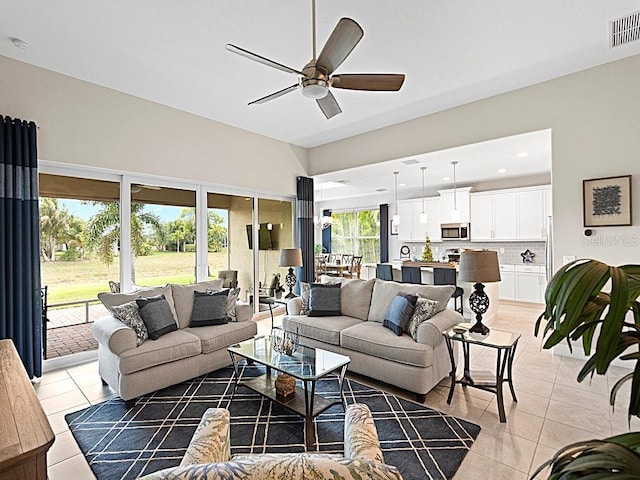 living room featuring a wealth of natural light, light tile patterned floors, and ceiling fan