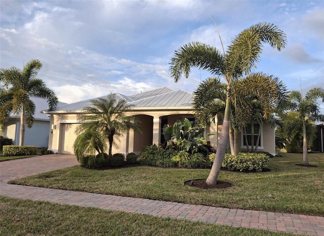 view of front of home with a garage and a front lawn