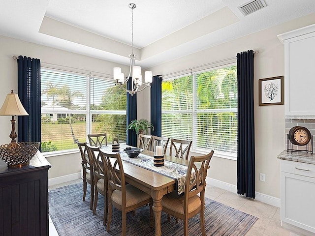 dining area with light tile patterned floors, plenty of natural light, and a raised ceiling