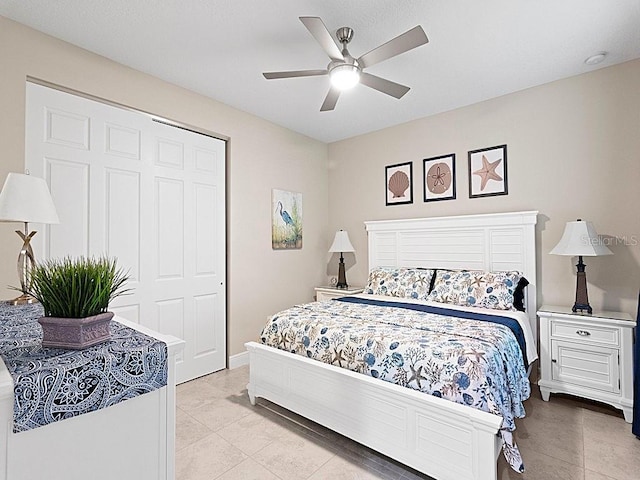 bedroom featuring light tile patterned flooring, ceiling fan, and a closet