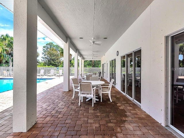 view of patio / terrace featuring a fenced in pool and ceiling fan