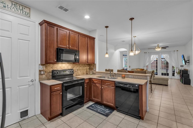 kitchen featuring pendant lighting, black appliances, sink, kitchen peninsula, and ceiling fan