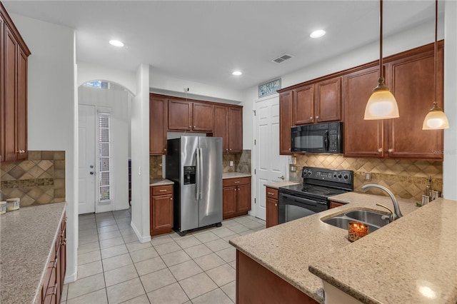 kitchen featuring sink, pendant lighting, backsplash, and black appliances