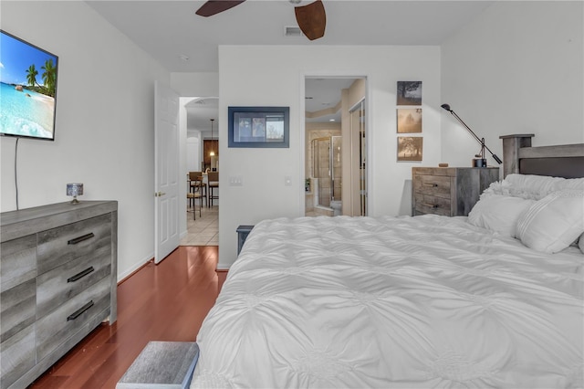 bedroom featuring ceiling fan, connected bathroom, and hardwood / wood-style flooring